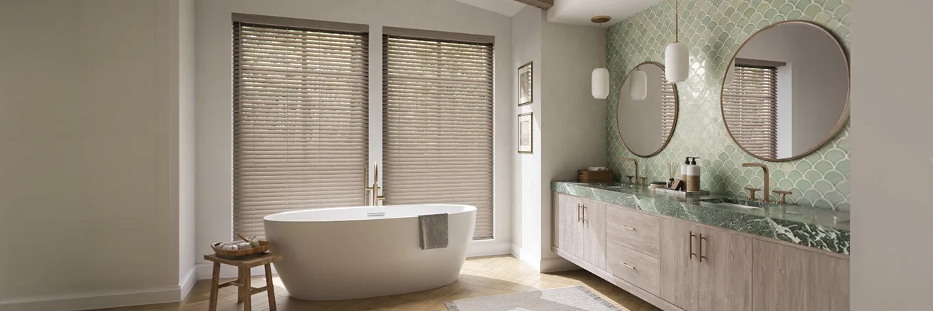 Contemporary window blinds cover windows behind a bathtub