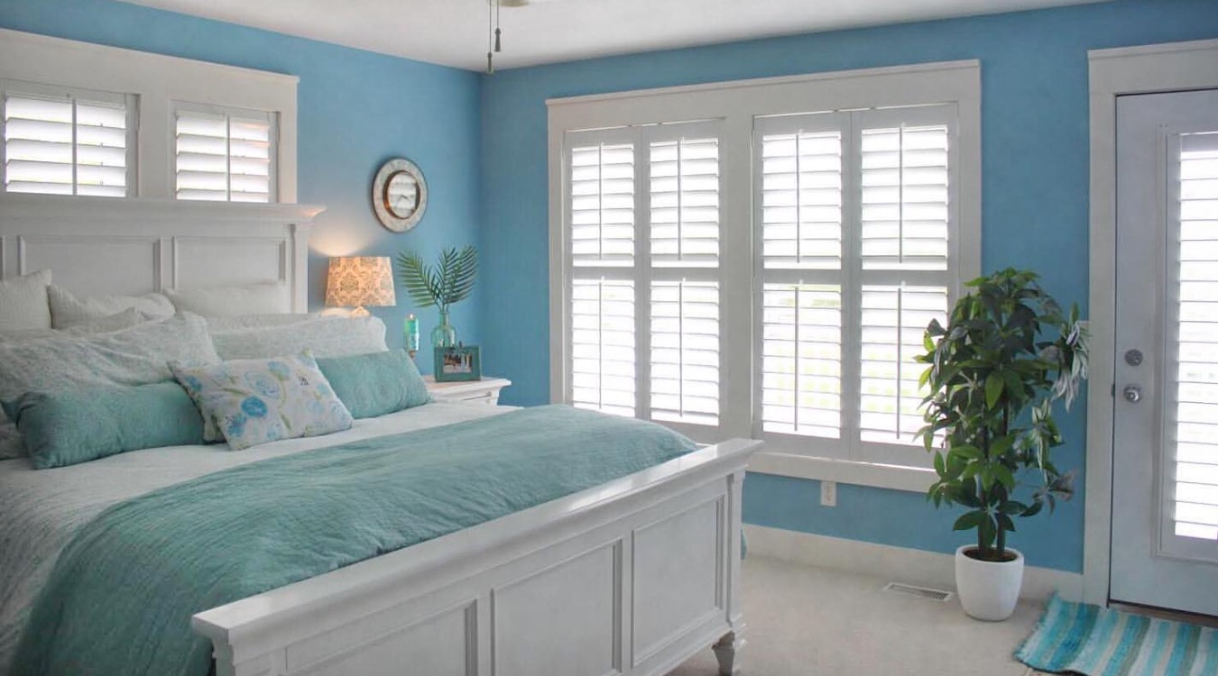 Blue bedroom with white shutters