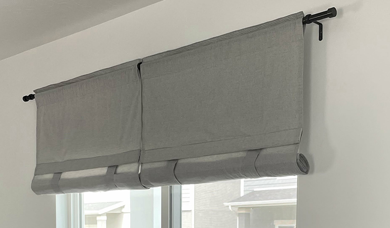 Gray rolled tumble shades in a dining room