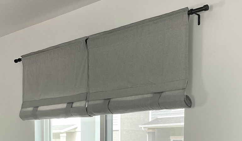 Tumble shades are perfect for sliding glass doors to the patio. Gray rolled tumble shades in a dining room