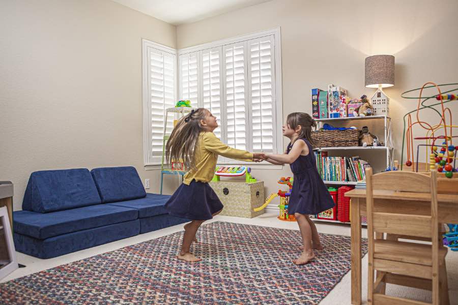 Choose Polywood shutters for durable, kid-friendly great room window treatments in San Antonio. Polywood shutters on multiple windows in a sitting area