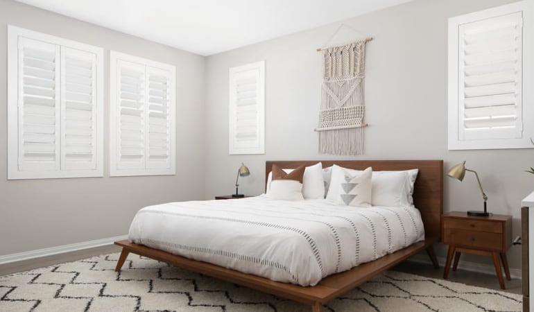 Open shutter louvers will help any San Antonio room feel larger. Plantation shutters in a model home bedroom.