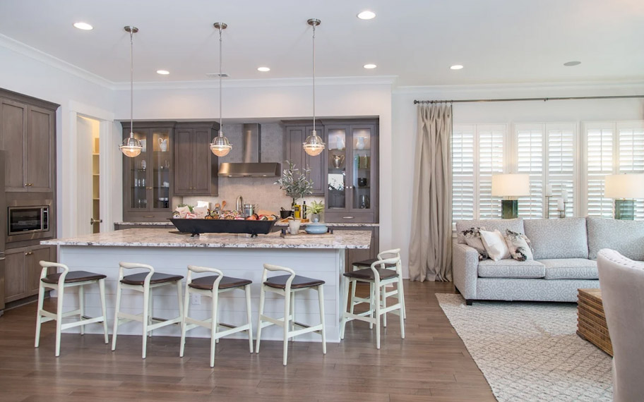 Illuminate your home with custom interior shutters in San Antonio. White arched shutters in a white kitchen with lots of light.