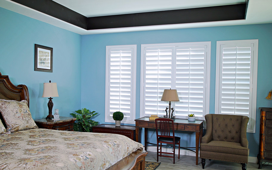 Polywood shutters provide insulation for the perfect temperature all year long in San Antonio. Polywood shutters in a bedroom.