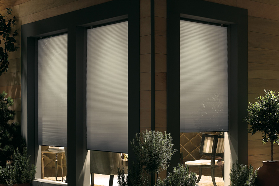 Cellular shades are modern and stylish window treatments for your home in San Antonio. Dark gray cellular shades displayed from the exterior of a home.