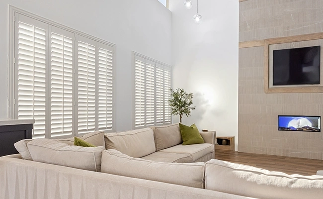 White Polywood shutters in a large beige living room