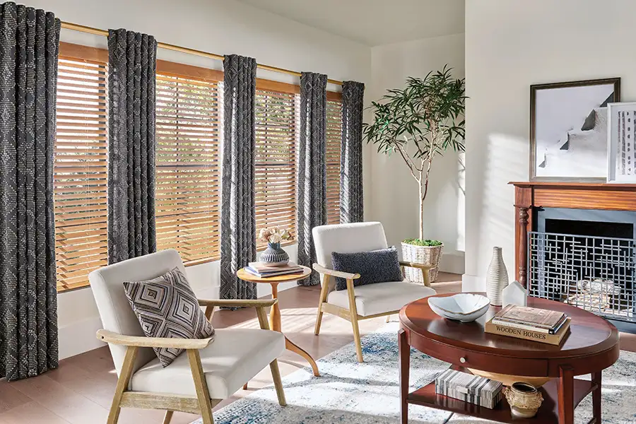 Wood blinds and gray patterned drapes on windows in a contemporary living room